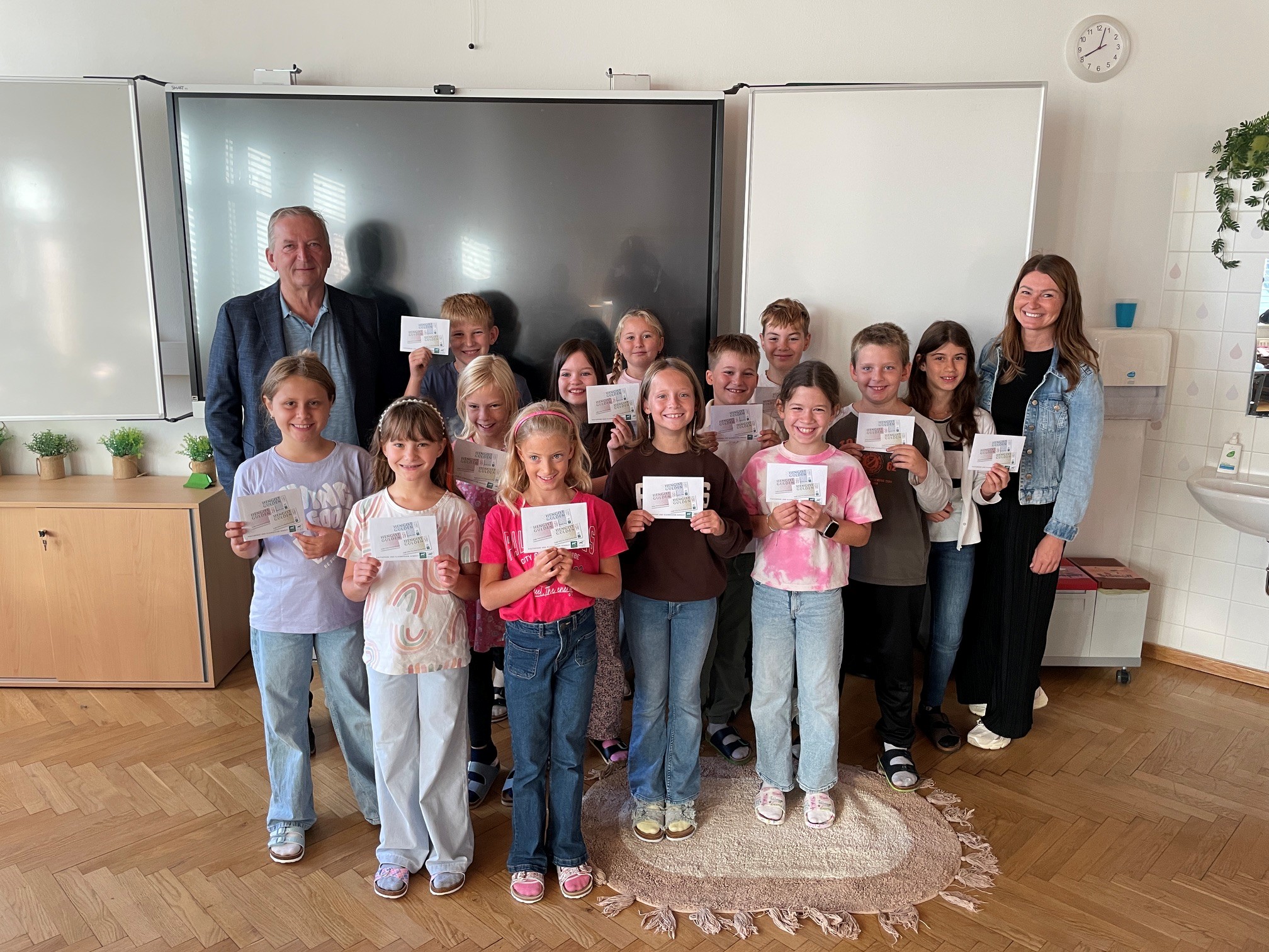 Schulklasse mit Lehrern und Urkunden in einem Klassenzimmer